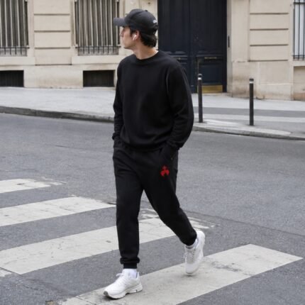 Gros plan sur la broderie chrétienne Caritas d'un pantalon de survêtement homme