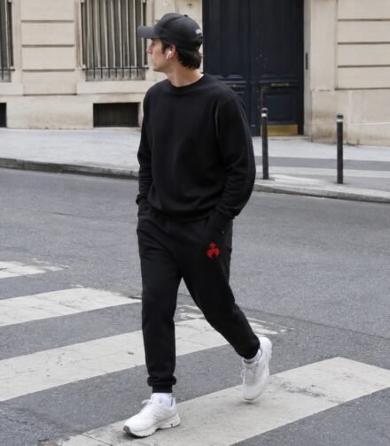 Gros plan sur la broderie chrétienne Caritas d'un pantalon de survêtement homme