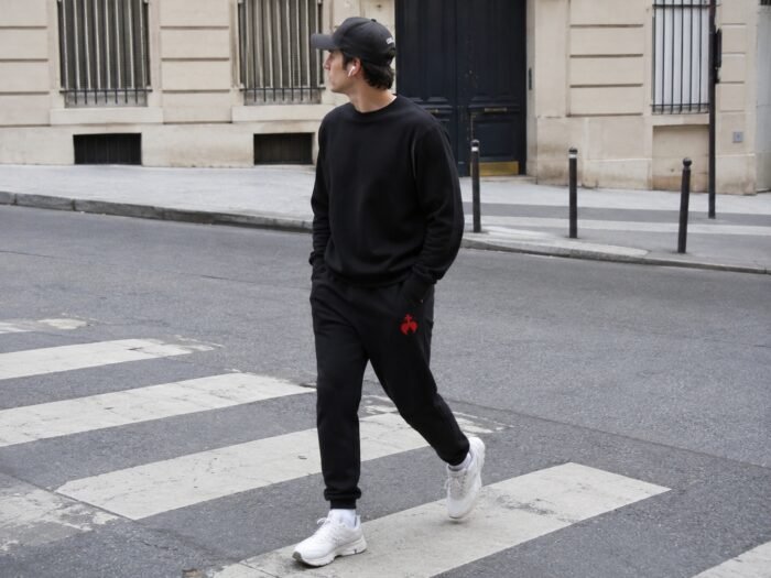 Gros plan sur la broderie chrétienne Caritas d'un pantalon de survêtement homme
