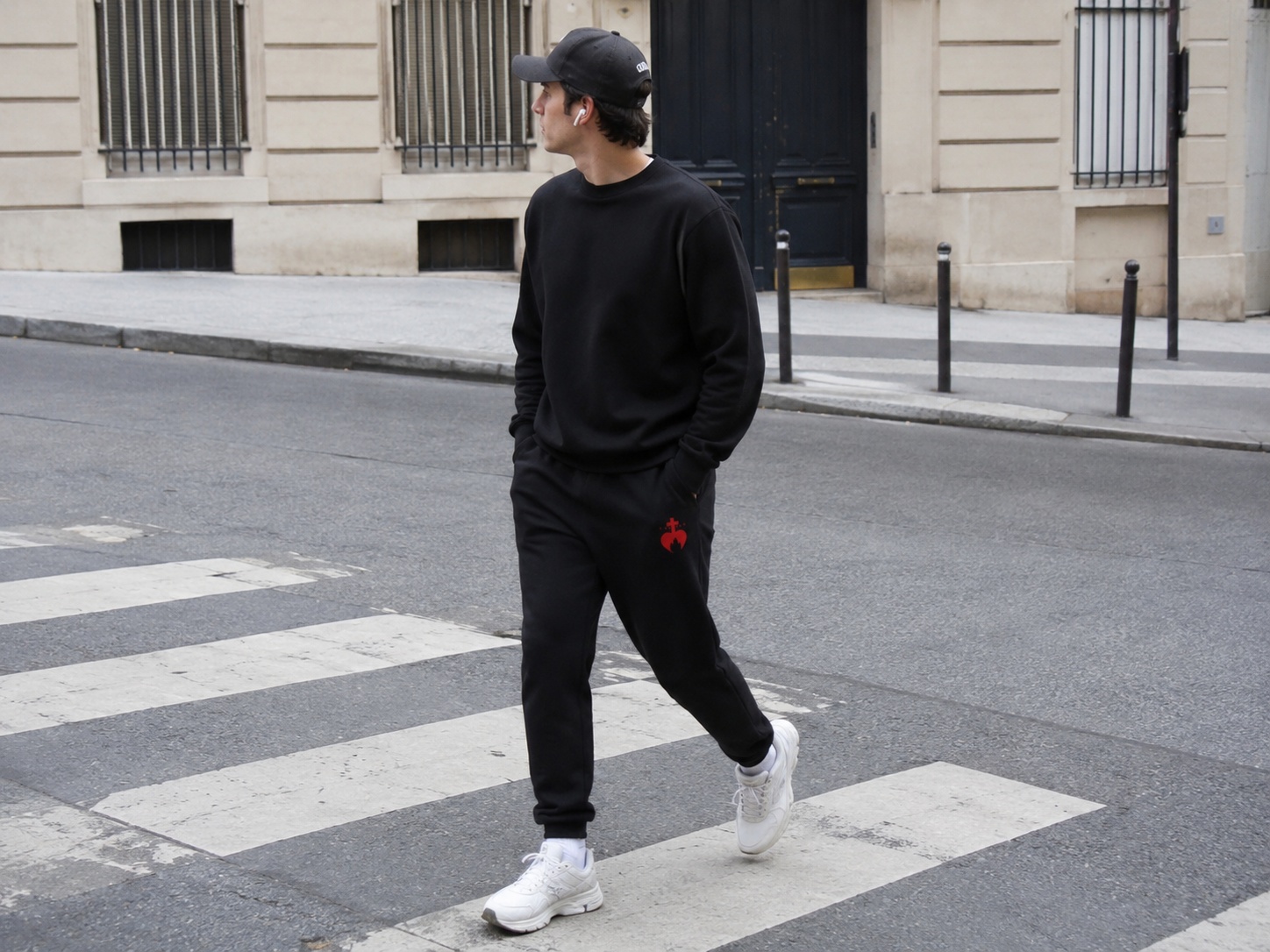 Gros plan sur la broderie chrétienne Caritas d'un pantalon de survêtement homme