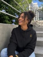 femme portant le sweat à capuche chrétien Chrisme en coton bio (couleur noire)